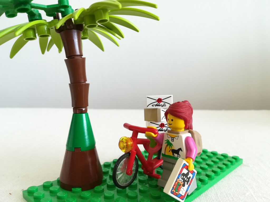 Lego-ukko ja pyörä täynnä paketteja